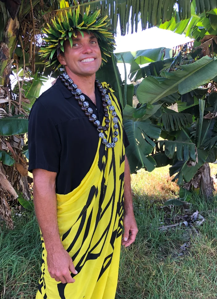 IMG_1457 A man in a yellow and black dress with a lei around his neck.